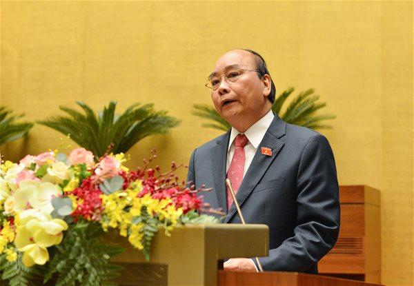 Thủ tướng Nguyễn Xuân Phúc trình bày báo cáo trước Quốc hội sáng 24-3. Ảnh: quochoi.vn