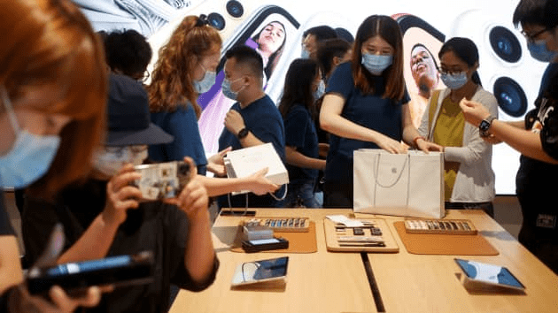 People purchase Apple products in the new Apple flagship store on its opening day following an outbreak of the coronavirus disease (COVID-19) in Sanlitun in Beijing, China, July 17, 2020.