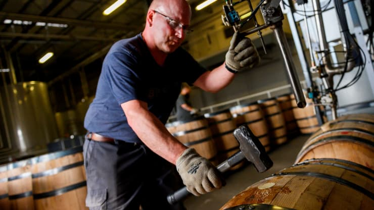An employee at the Bardstown Bourbon Company seals a barrel after it was filled with bourbon in Bardstown, Kentucky on April 11, 2019.
