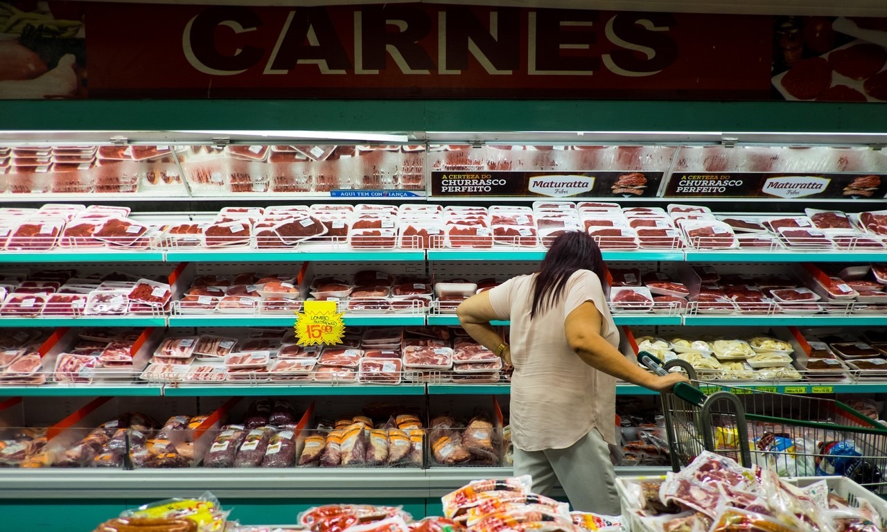 Một người tiêu dùng xem thịt trong siêu thị ở São Paulo, Brazil.