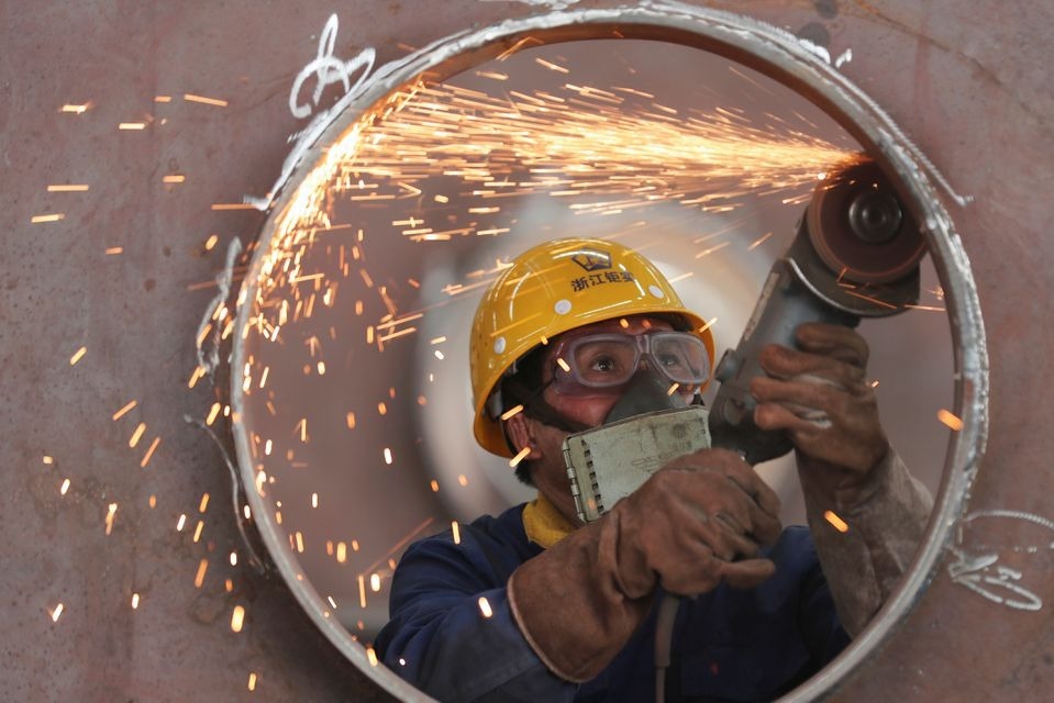 Một công nhân làm việc trong nhà máy cơ khí ở Hồ Châu, Chiết Giang, Trung Quốc ngày 17/5/2020. Ảnh: Reuters.