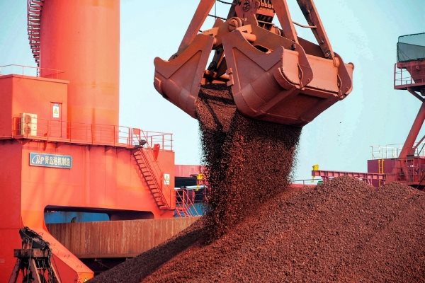 Quặng sắt được bốc dỡ tại một cảng ở Thanh Đảo, tỉnh Sơn Đông, Trung Quốc. Các tập đoàn khai khoáng được hưởng lợi khi giá quặng sắt tăng lên mức kỷ lục trong năm nay nhờ nhu cầu mạnh mẽ của Trung Quốc. Ảnh: AFP