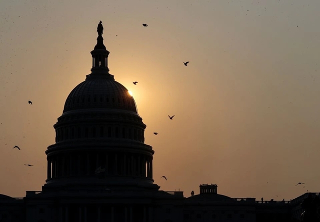 Mặt trời mọc phía sau tòa nhà quốc hội Mỹ ngày 13/9. Ảnh: Reuters.