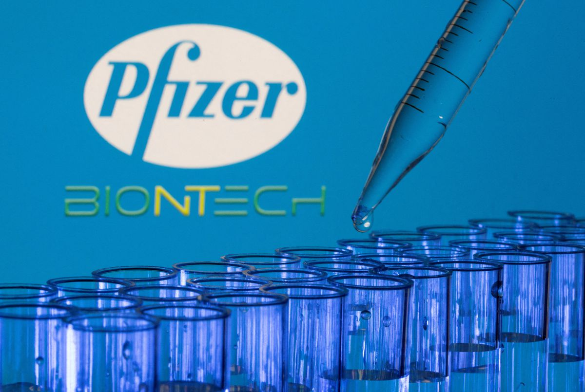 Các ống nghiệm được nhìn thấy phía trước logo Pfizer và Biontech được hiển thị trong hình minh họa này