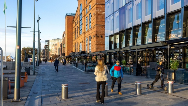 Pedestrians pass restaurants and retail stores in Oslo, Norway. Photographer: Fredrik Solstad/Bloomberg